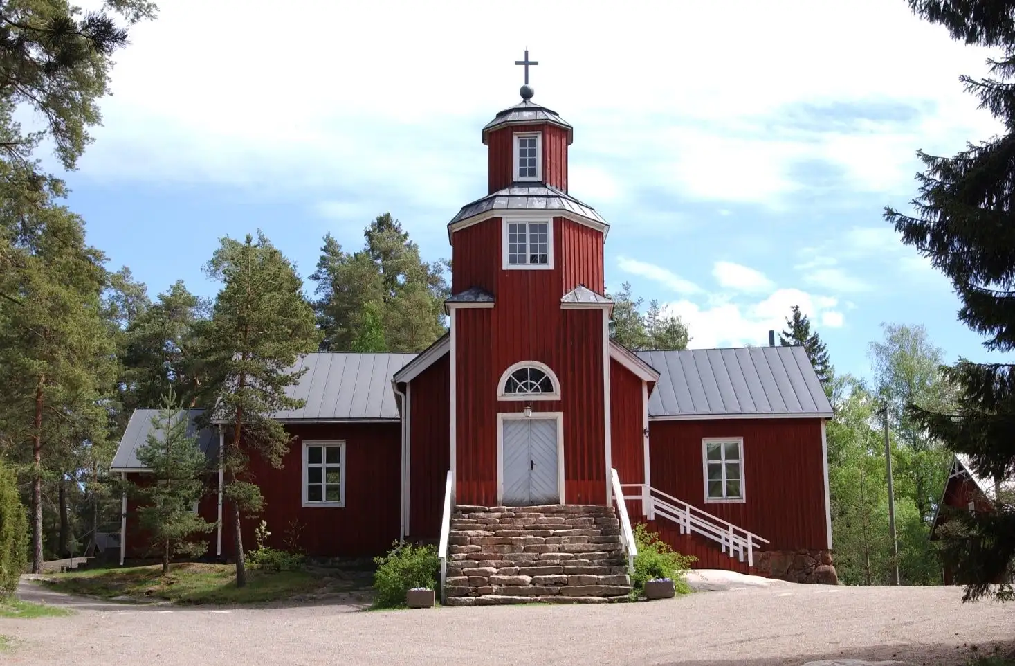The red-ochre wooden church of Haapajärvi with its bell tower in summer