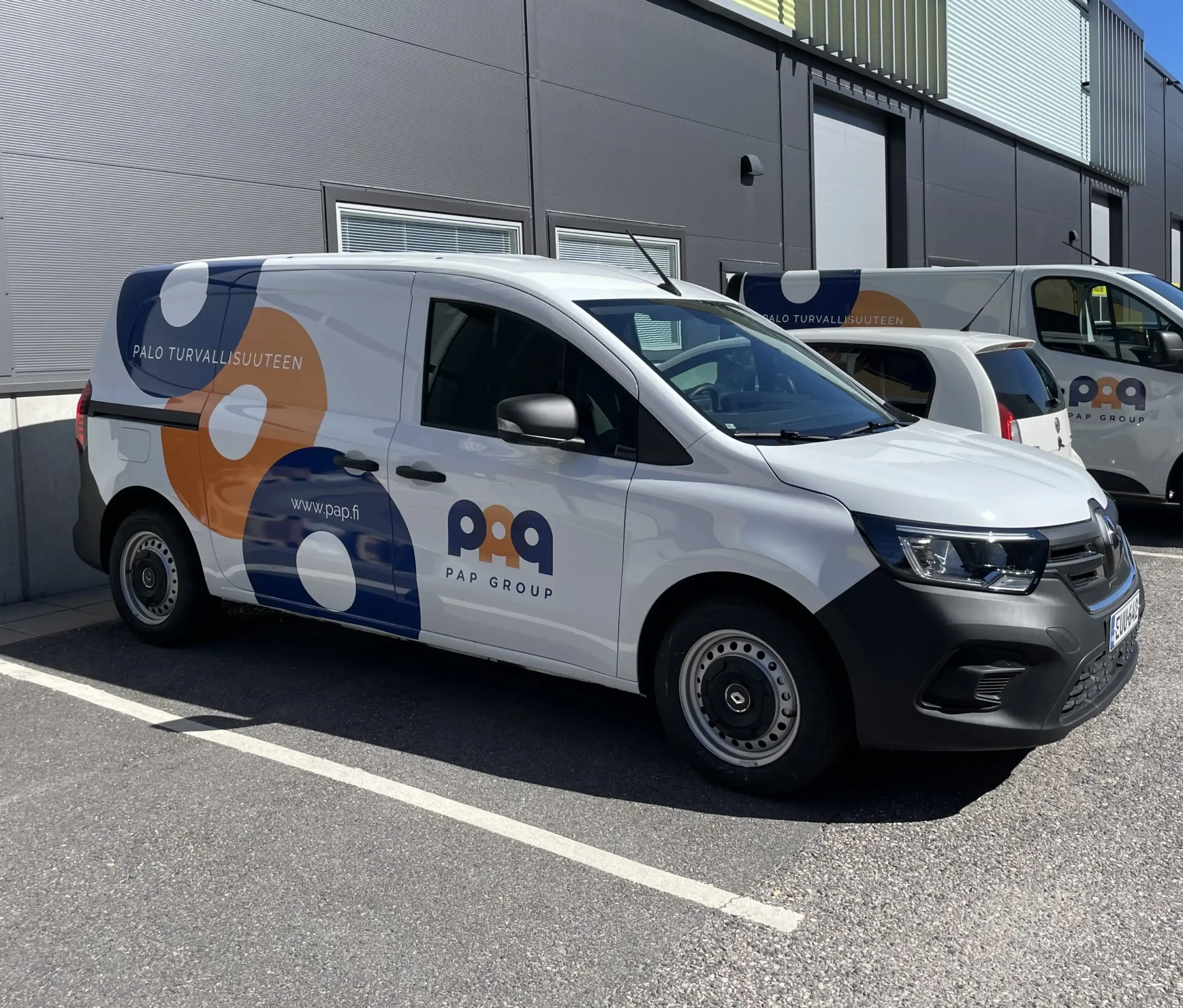 PAP Groups paketbil parkerad framför en byggnad