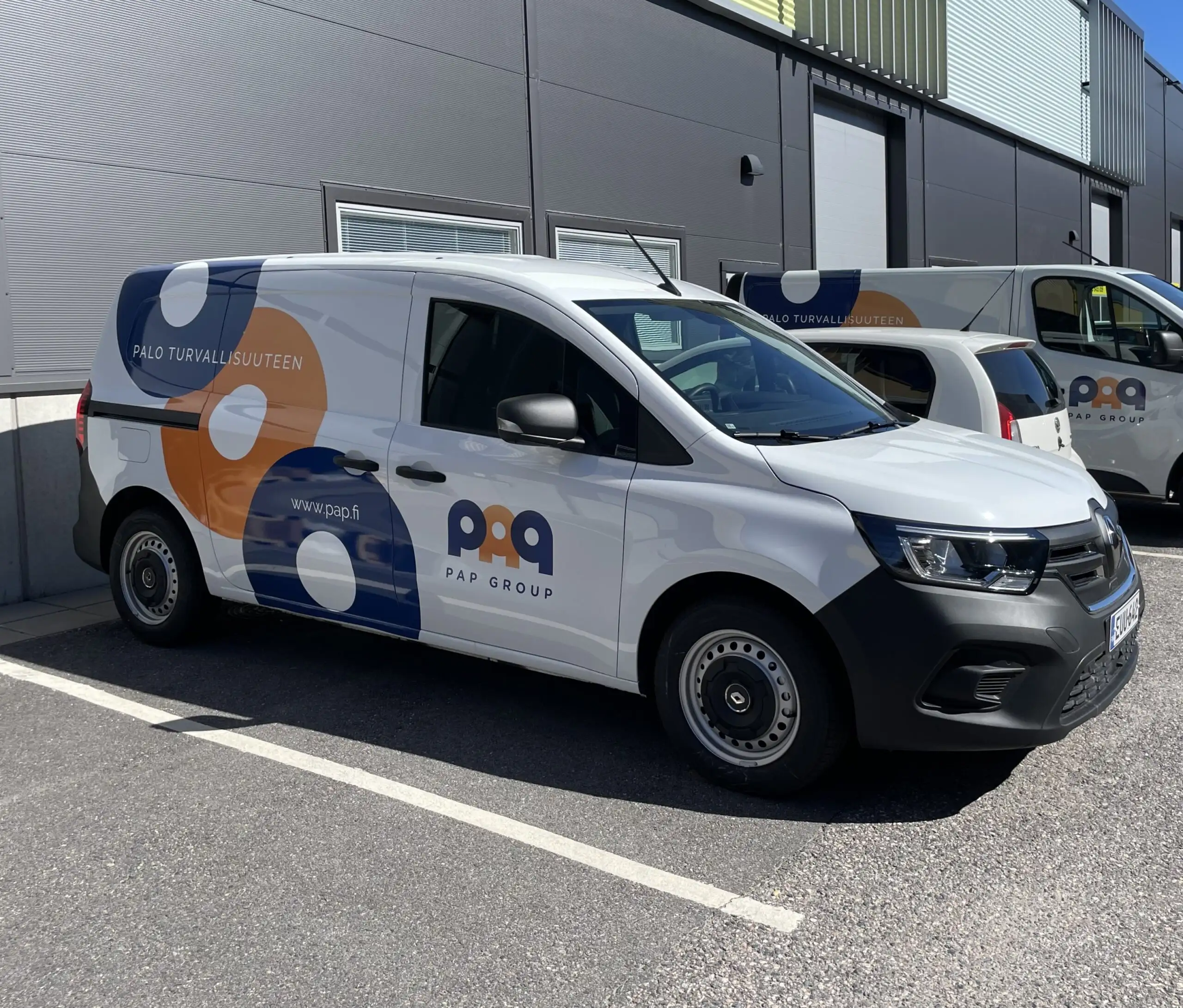 PAP Groupin tunnuksin teipattu sähköpakettiauto pysäköitynä